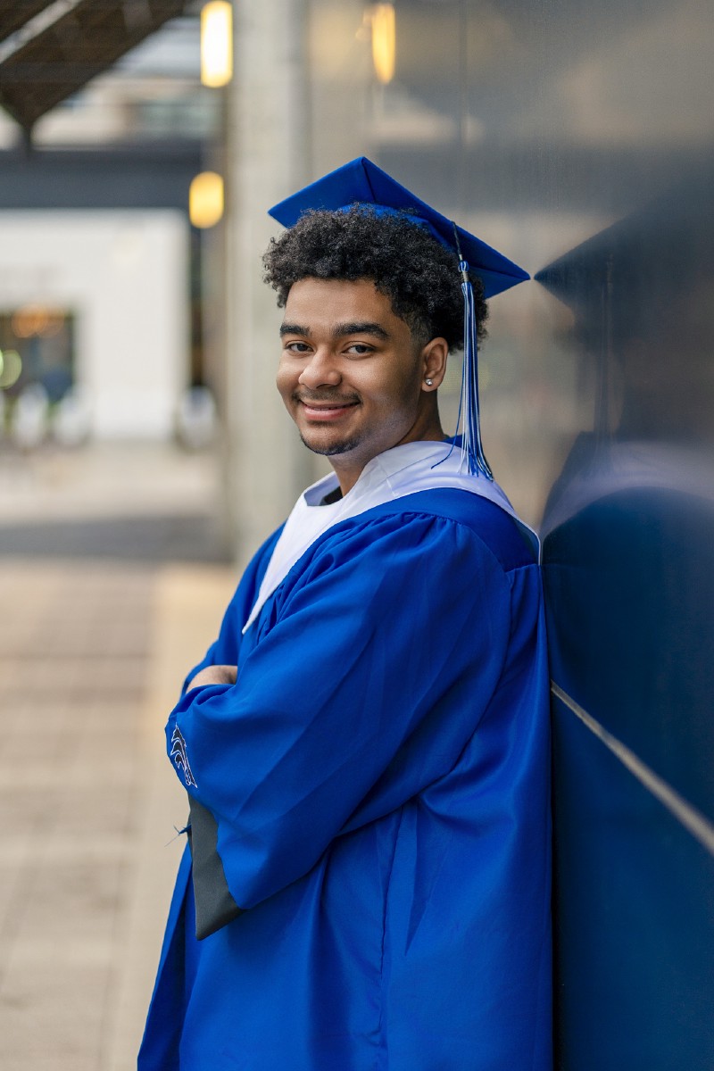 Senior portrait of Jadan in cap and gown at Legacy West in Plano