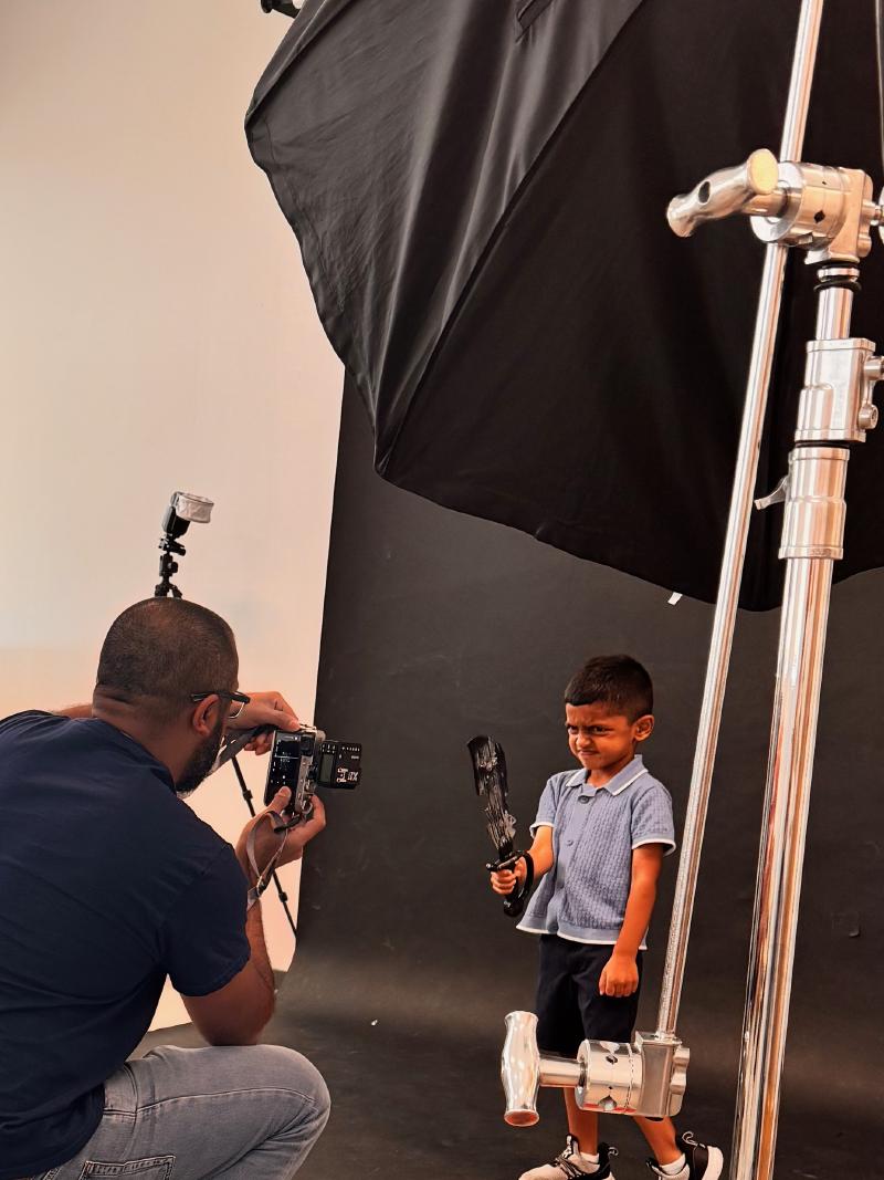 Amer Khalid setting up studio lighting for a portrait session