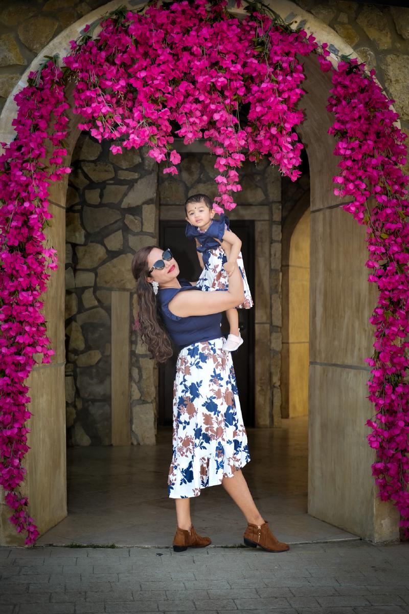 Family portrait under a flower arch at Adriatica Village in McKinney