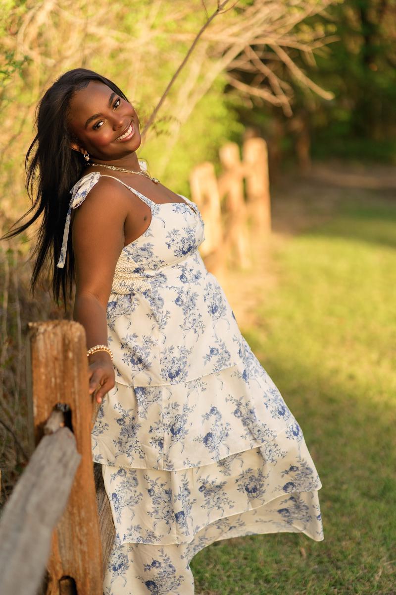 Senior portrait of Zoe in a lightweight cream floral sundress at golden hour in Frisco