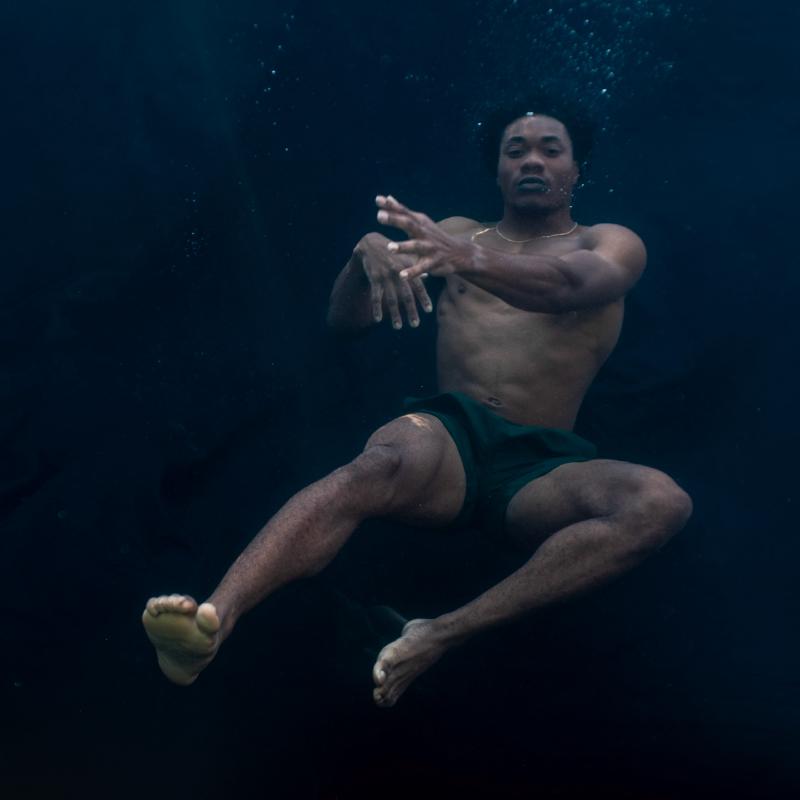 Full body underwater portrait pose with arms extended